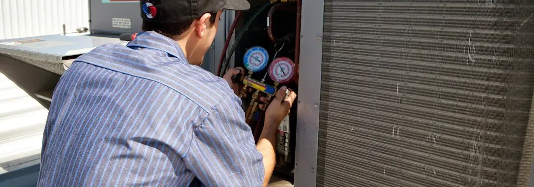 HVAC technician servicing a condenser unit in Fort Oglethorpe